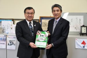 橋浦専務㊨から境教育長㊧へ教材本を寄贈