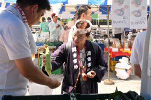 石巻産のトウモロコシを購入する来場者